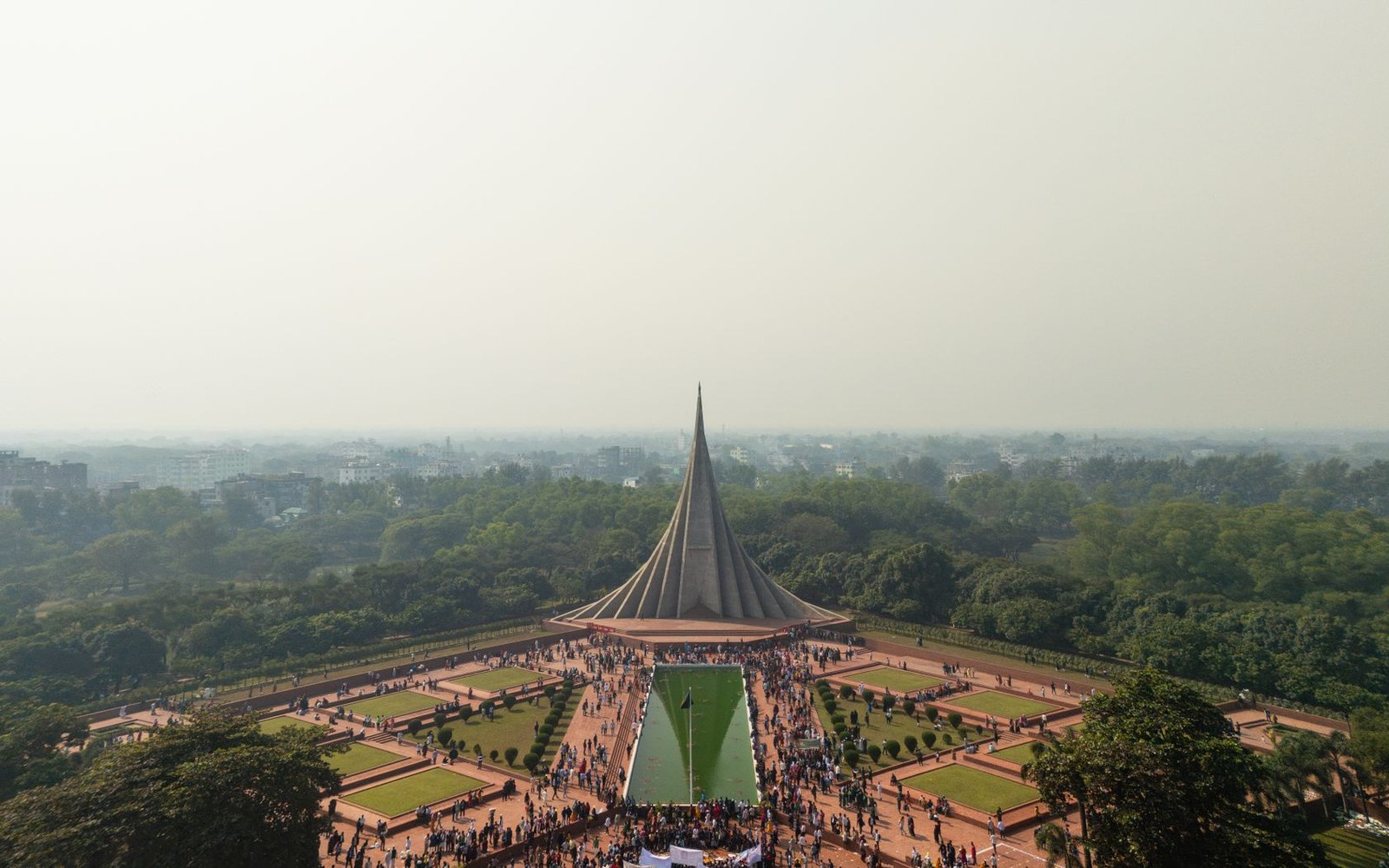 Aerial view of the National Martyrs' Memorial with crowds gathered amid landscaped gardens