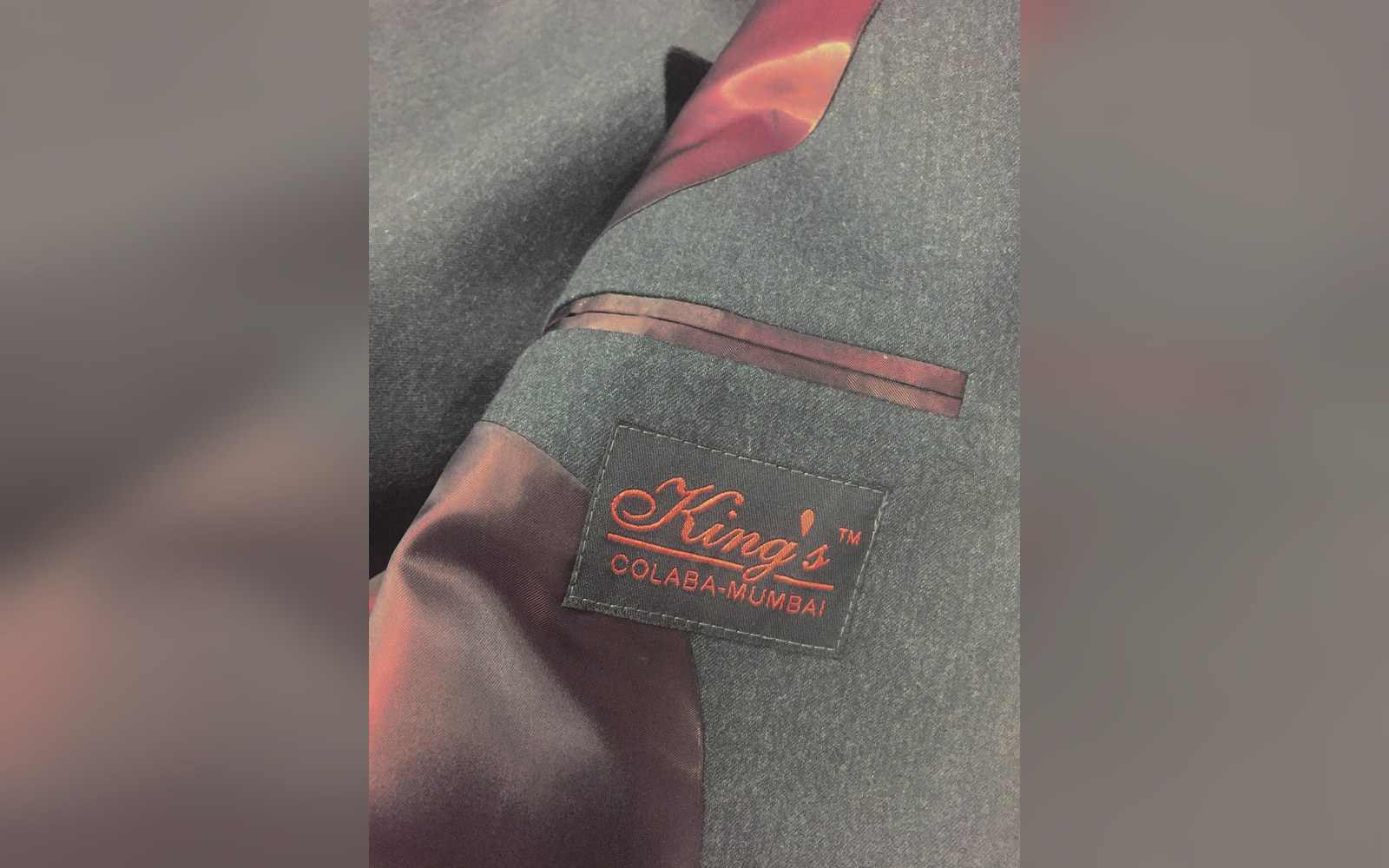 Close-up of a grey suit jacket with a King's Colaba-Mumbai tailor label sewn inside