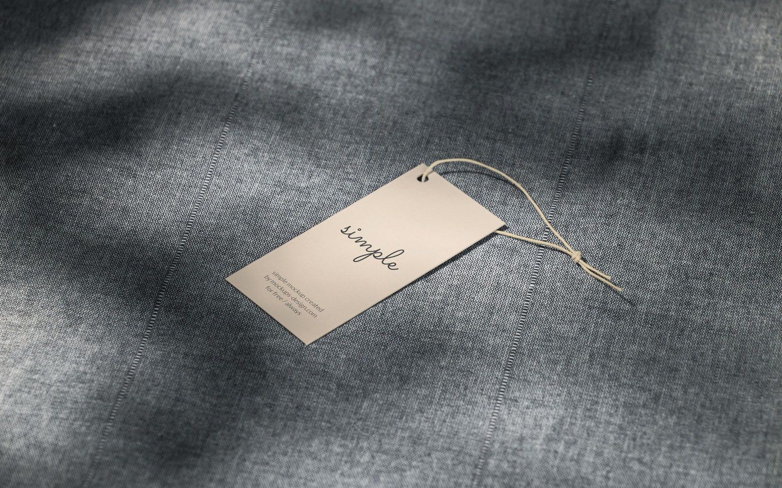 A tag reading "simple" tied with string on a folded denim garment